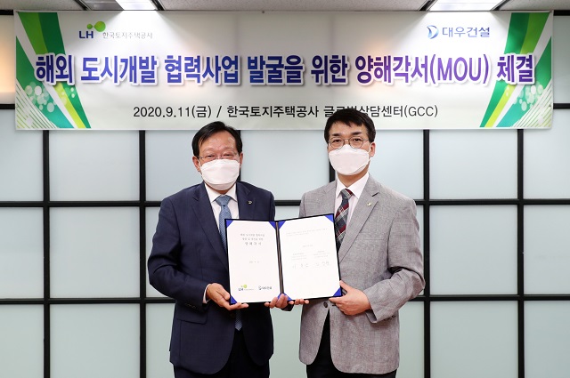 ▲ 김창환 대우건설 신사업본부장(왼쪽)과 이용삼 한국토지주택공사(LH) 글로벌사업본부장이 양해각서를 체결하고 기념촬영을 하고 있다.ⓒ대우건설