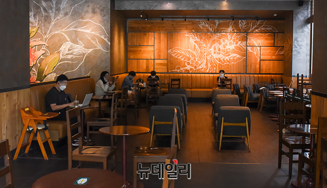 ▲ 수도권의 사회적 거리두기 2.5단계 조치가 2단계로 하향조정된 14일 오전 서울 서초구 한 프랜차이즈 커피전문점 내에서 고객들이 음식물을 섭취하고 있다. ⓒ박성원 기자