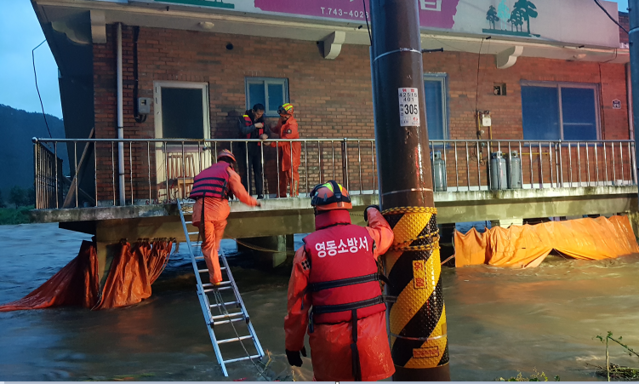 ▲ 지난달 집중호우 당시 주택침수로 고립된 주민들을 구조하는 소방대원들.(자료사진)ⓒ충북소방본부