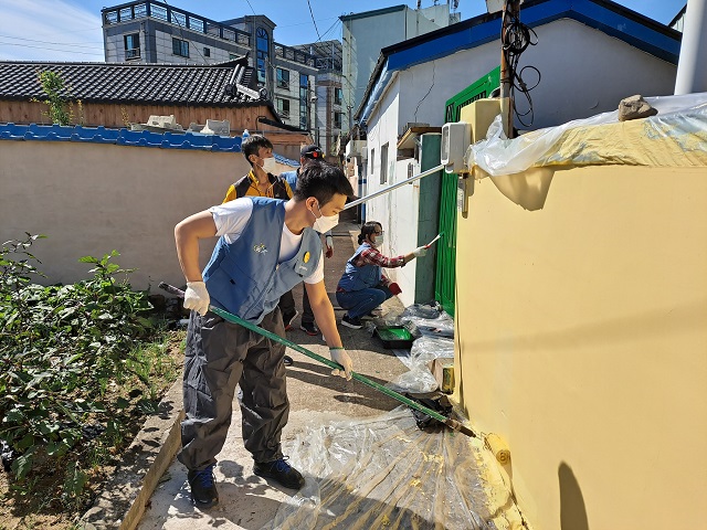 ▲ 포항제철소 직원들이 청림동 주택가에서 노후된 담장을 깨끗하게 도색하고 있다.ⓒ포항제철소