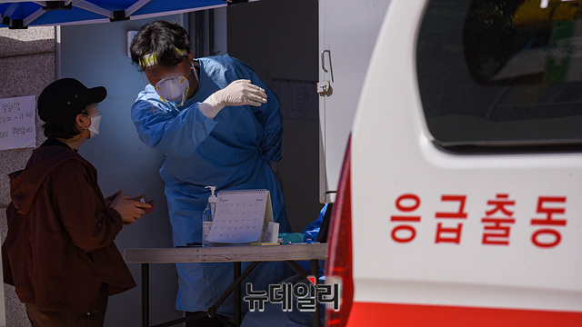 ▲ 국내 '코로나19(중국 우한 폐렴)' 확진자가 나흘 만에 다시 세 자릿수가 된 23일 오전 서울 구로구보건소에 마련된 선별진료소에서 의료진이 문진을 하고 있다. ⓒ박성원 기자