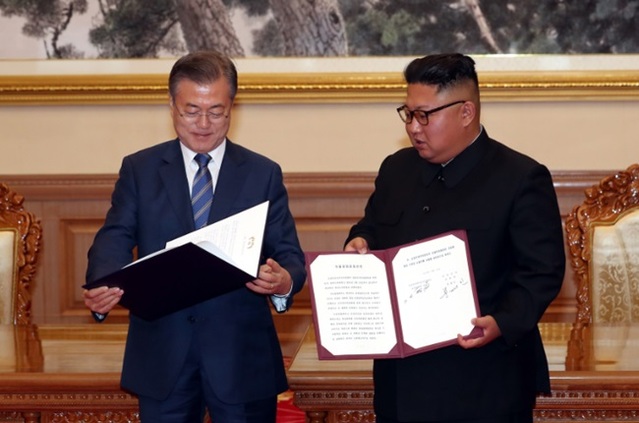 문재인 대통령과 북한 김정은이 2018년 9월 19일 백화원 영빈관에서 정상회담을 마친 뒤 평양공동선언서에 서명하는 모습.ⓒ평양사진공동취재단