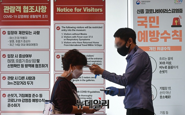 ▲ 사회적 거리두기 1단계로 전환된 12일 오후 서울 종로구 국립고궁박물관을 방문한 관람객이 체온을 측정하고 있다. ⓒ권창회 기자