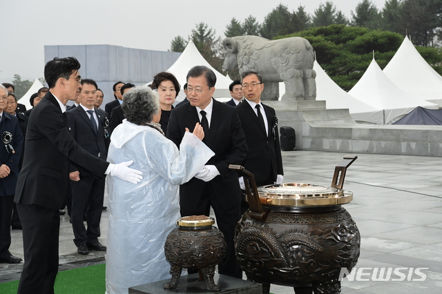 ▲ 문재인 대통령이 지난 3월 국립대전현충원에서 열린 서해수호의 날 기념식에 참석해 분향하는 가운데 고(故)민평기 상사의 모친이 대통령에게 질문을 하고 있다. ⓒ뉴시스
