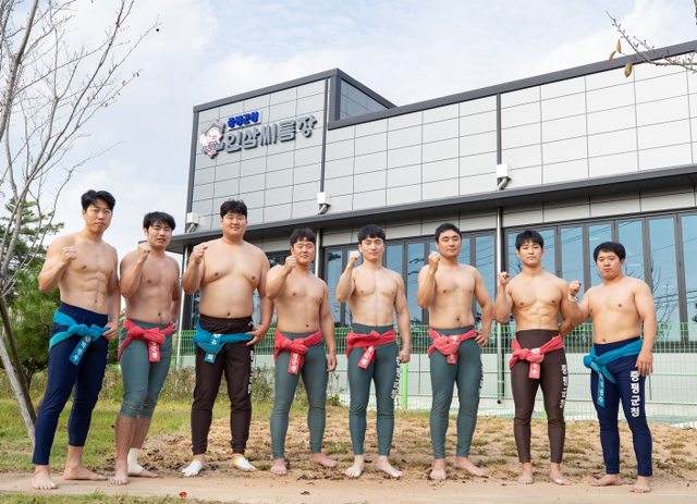 ▲ 새로 지어진 훈련장 앞에서 포즈를 취한 증평 인삼씨름단 선수들.ⓒ증평군