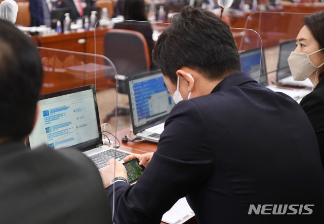 ▲ 22일 국회에서 열린 산업통상자원중소벤처기업위원회의 산업통상자원부 등 종합감사에서 국감 도중 자신의 휴대전화로 모바일 게임 '캔디크러시'를 하고 있는 강훈식 더불어민주당 의원의 뒷모습. 오른쪽에는 같은 당 고민정 의원의 모습이 보인다.(공동취재사진) ⓒ뉴시스