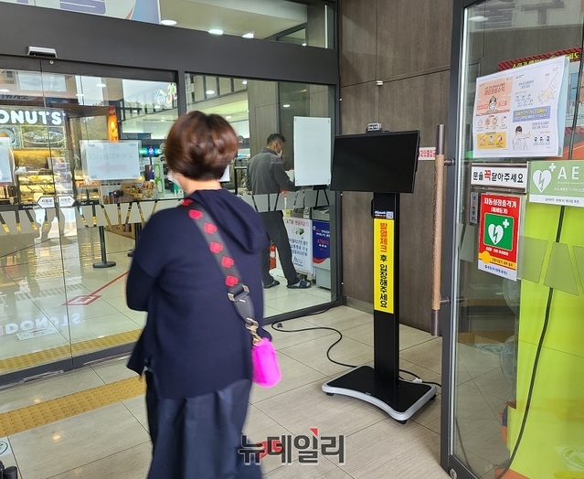 ▲ 경부고속도로 하행선 죽암휴게소 푸드코너 입구에 설치된 스텐드형 발열체크기가 고장난 채 방치된 가운데 한 고객이 발열체크 없이 그대로 진입하고 있다.ⓒ김정원 기자