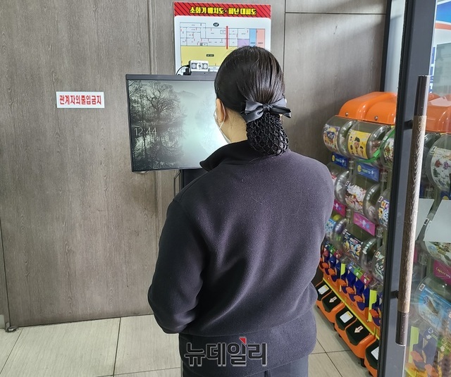 ▲ 경부고속도로 하행선 죽암휴게소 푸드코너 입구에 설치된 발열체크기가 고장난 채 방치된 가운데 휴게소 여직원이 작동을 하고 있다.ⓒ김정원 기자