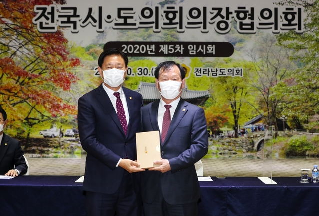 ▲ 고우현 경북도의회 의장(오른쪽)은 지난 30일 전남 장성에서 열린 2020년 전국시도의회의장협의회 제5차 임시회에서 ‘지방소멸위기지역 지원 특별법 제정 촉구 건의문’을 제출했다.ⓒ경북도의회