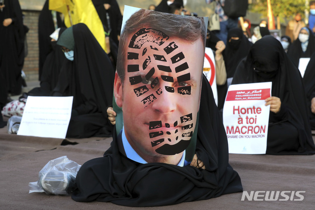 ▲ [테헤란=AP/뉴시스] 지난달 28일(현지시각) 이란 수도 테헤란의 프랑스 대사관 앞에서 에마뉘엘 마크롱 프랑스 대통령과 선지자 무함마드에 대한 만평에 항의하는 시위가 열려 한 여성이 발자국 찍힌 마크롱 대통령의 사진을 들고 있다. 중동지역과 세계의 이슬람교도들은 프랑스 제품에 대한 불매 운동과 만평에 대한 시위를 이어가고 있다. ⓒ뉴시스