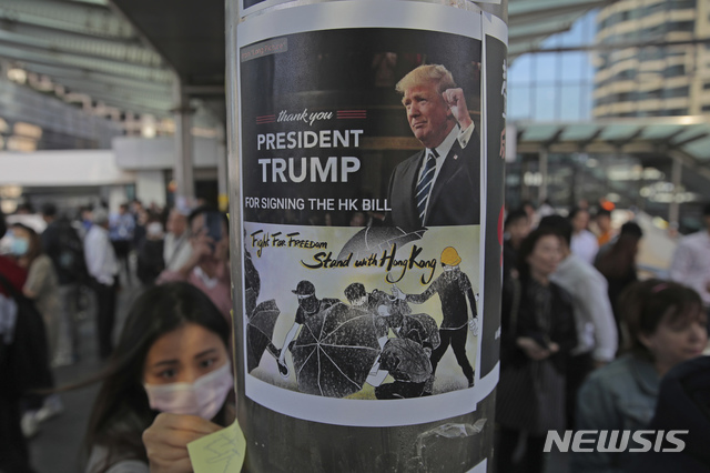 ▲ [홍콩=AP/뉴시스] 지난해 11월 28일(현지시각) 홍콩 시위대가 시내 금융가에서 시위를 벌이며 도널드 트럼프 미국 대통령의 홍콩 인권법 서명에 고마움을 표하는 포스터를 기둥에 붙이고 있다. ⓒ뉴시스