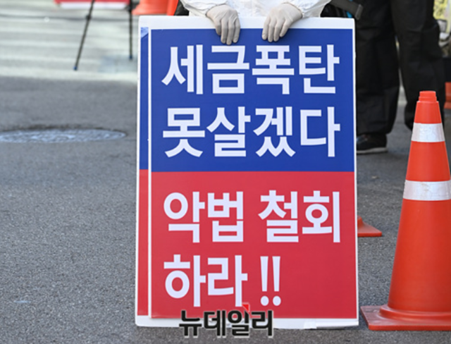 ▲ 지난 6월17일 오후 서울 여의도 더불어민주당 중앙당사 앞에서 한 시민이 '세금 폭탄 못 살겠다'며 피켓 시위를 하고 있다. ⓒ박성원 기자