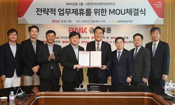 ▲ 김지완 BNK금융지주 회장(오른쪽에서 네번째)이 지난 9일 부산은행 본점에서 카카오엔터프라이즈와 'AI기술 활용을 위한 전략적 업무 협약'을 체결한 뒤 기념촬영을 하고 있다. ⓒBNK금융그룹