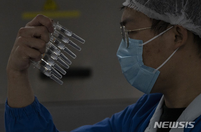 ▲ 중국 시노백 직원이 우한코로나 백신을 살펴보고 있다. ⓒ뉴시스 AP. 무단전재 및 재배포 금지.