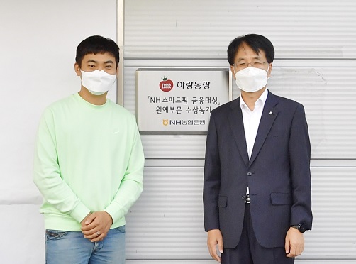 ▲ 손병환 농협은행장(오른쪽)과 허정수 하랑농장 대표(왼쪽)가 12일 전북 김제시에 위치한 ‘하랑농장’에서 ‘NH 스마트팜 금융대상’ 현판식을 진행하고 기념촬영을 하고 있다 ⓒ농협은행