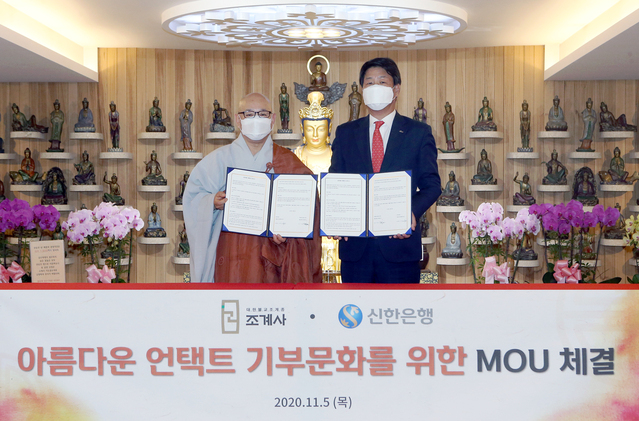 ▲ 신한은행은 지난 5일 서울 종로구 우정국로 소재 조계사 관음전에서 조계사와 업무협약을 체결했다. 협약식을 마치고 신한은행 이명구 부행장(오른쪽)과 조계사 주지 지현스님이 기념촬영을 하고 있다.ⓒ신한은행