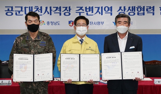 ▲ 충남도와 공군, 보령시가 19일 13년째 갈등이 이어져 온 사격장 환경피해 갈등과 관련해 양승조 충남지사와 이동원 공군 방공유도탄사령관, 김동일 보령시장이 19일 충남도청에서 상생협력 합의서에 서명한 뒤 사진 촬영을 하고 있다.ⓒ충남도