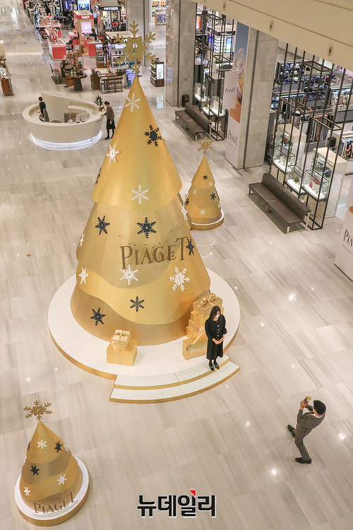 ▲ 24일 오전 현대백화점 판교점 1층 중앙광장에 설치된 ‘피아제 크리스마스트리’ 앞에서 고객들이 기념 촬영을 하고 있다. ⓒ현대백화점