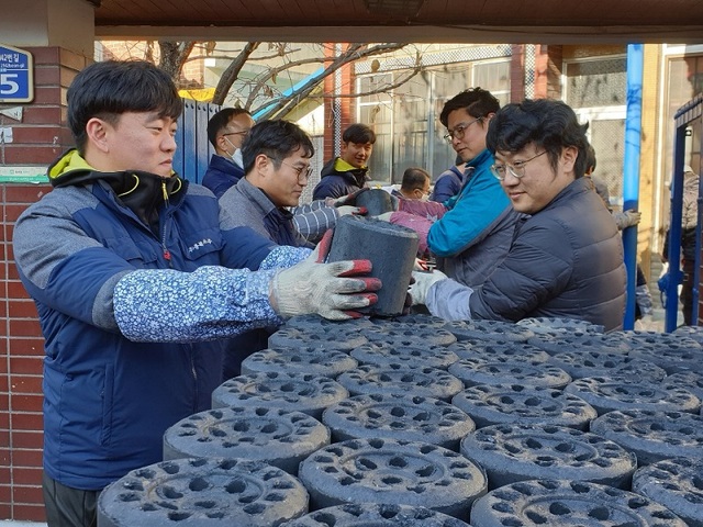 ▲ 충북소주 직원들이 12일 청주시 서원구 모충동에서 저소득층 가구에 연탄을 배달하고 있다.(2019년 자료사진) ⓒ충북소주
