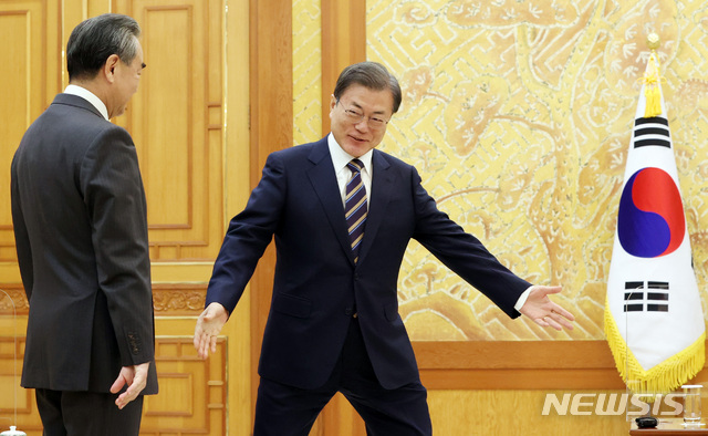 ▲ 문재인 대통령이 26일 오후 청와대에서 왕이(王毅) 중국 외교담당 국무위원 겸 외교부장을 접견, 기념촬영을 위해 자리를 안내하고 있다. ⓒ뉴시스