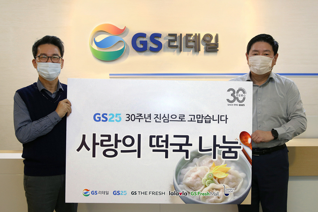 ▲ GS리테일 대표이사 허연수 부회장(사진 오른쪽)과 조윤성 사장(왼쪽)이 GS25의 '릴레이 떡국나눔'의 시작을 기념하며 사진을 촬영하고 있다.ⓒGS리테일