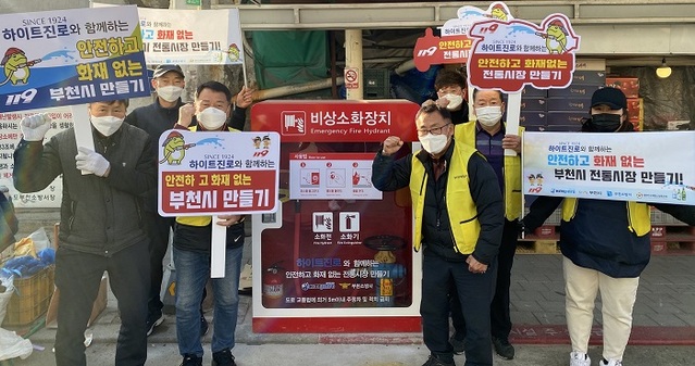 ▲ 하이트진로는 ‘안전하고 화재없는 전통시장 만들기’ 국민안전캠페인의 일환으로 부천시전통시장과 화재취약지역에 비상소화장치 7대를 설치했다.새로 설치한 비상소화장치 앞에서 포즈를 취하고 있는 부천제일시장 상인들.ⓒ하이트진로