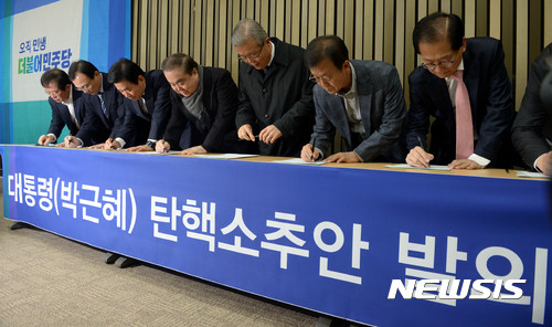 ▲ 김종인 국민의힘 비상대책위원장(가운데)이 지난 2016년 11월29일 민주당 의원 당시 박근혜 전 대통령 탄핵소추안 발의에 서명하고 있다.ⓒ뉴시스