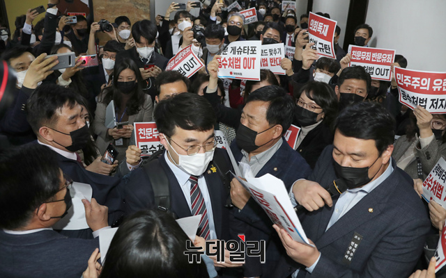 ▲ 더불어민주당 법안심사 소위 소속 의원들이 7일 오후 국회 법사위 법안심사제1소위 회의실 앞에서 공수처법 개정안에 반대하며 구호를 외치고 있는 국민의힘 의원들을 지나 회의장으로 들어서고 있다. ⓒ이종현 기자(사진=공동취재단)