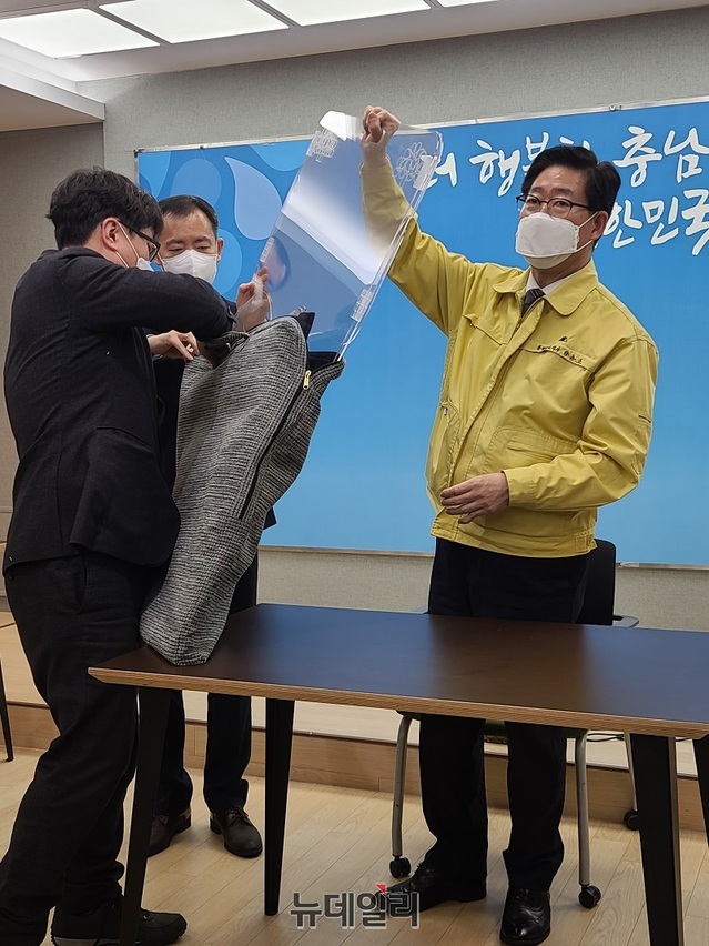 ▲ 양승조 도지사가 29일 도청에서 휴대용 비말차단기를 소개한 뒤 이동하기 편리하게 제작된 케이스에 담아 보이고 있다.ⓒ김정원 기자