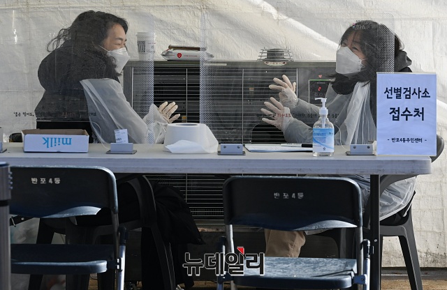 ▲ 30일 오전 서울 서초구 파리15구 공원에 마련된 임시 선별검사소에서 의료진이 난로에 손을 녹이고 있다. ⓒ권창회 기자