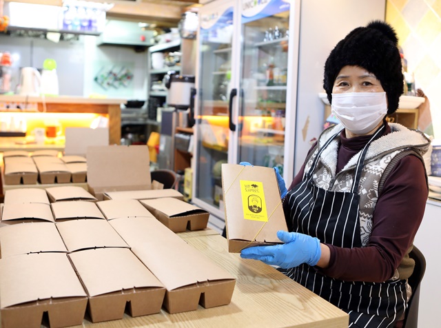 ▲ 남촌상인회 윤남순 회장이 명동밥집에 보낼 도시락을 포장하고 있다. ⓒSK