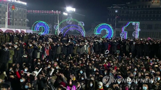 ▲ 북한 조선중앙TV는 평양 김일성광장에서 지난해 12월 31일 오후 11시부터 이달 1일 새벽까지 2021년 신년경축공연과 국기게양식, 불꽃놀이 실황을 생중계했다. 사진은 외투와 털모자, 귀마개 등으로 중무장하고 마스크를 쓴 채 국기가 올라가는 모습을 지켜보는 광장의 주민들. [조선중앙TV 화면] ⓒ연합뉴스