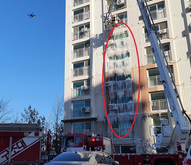 ▲ 진천소방서가 8일 드론을  이용해 벽암리 한 아파트에 생긴 15m가량의 고드름을 제거하고 있다.ⓒ진천소방서