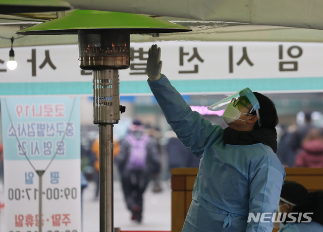 ▲ 12일 오후 서울 중구 서울역광장에 마련된 임시 선별검사소에서 관계자가 난로에 손을 녹이고 있다. ⓒ뉴시스