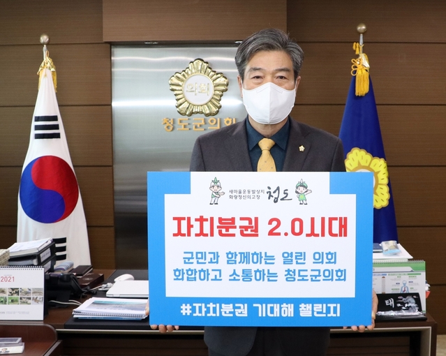 ▲ 이승율 청도군수로부터 지명을 받은 김수태 의장은 ‘자치분권 2.0시대. 자치분권 기대해’라는 문구가 적힌 팻말을 들고 캠페인을 이어갔다.ⓒ청도군의회