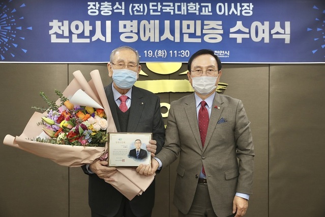 ▲ 장충식 전 단국대학교 이사장이 19일 천안시청 시장실에서 열린 천안시 명예시민증 수여식에서 박상돈 천안시장에게 명예시민증을 받은 뒤 기념 촬영을 하고 있다.ⓒ천안시