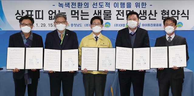 ▲ 양승조 충남도지사가 29일 도청에서 도내 하이트진로음료 등 먹는물 생산 업체와 상표 띠 없는 진환경 용기 사용 협약을 체결하고 있다.ⓒ충남도