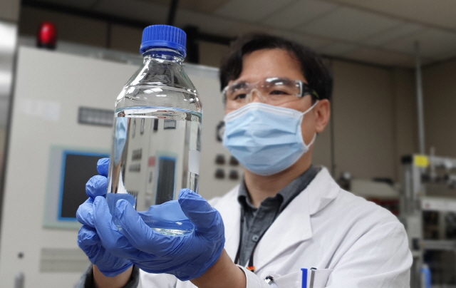 ▲ SK이노베이션 환경기술원 연구원이 열분해유를 들어보이고 있다. ⓒSK이노베이션