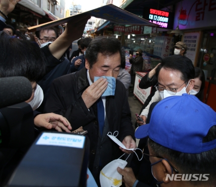 ▲ 이낙연 더불어민주당 대표가 5일 오후 민생탐방지로 찾은 강원도 춘천 중앙시장에서 중도유적지킴이본부 회원이 던진 계란을 맞고 손수건으로 닦고 있다. ⓒ뉴시스