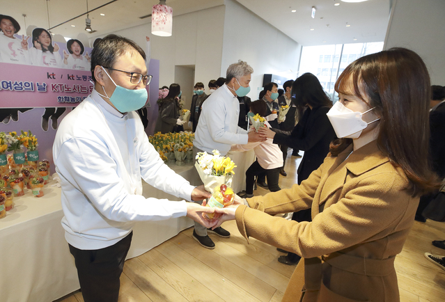 ▲ (왼쪽부터)KT 구현모 대표와 최장복 노조위원장이 광화문에 위치한 KT 이스트 사옥에서 여성 임직원에게 꽃을 나눠주고 있다.ⓒKT