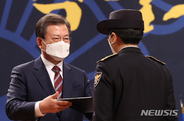 ▲ 문재인 대통령이 12일 오후 충남 아산시 경찰대학에서 열린 신임 경찰 경위·경감 임용식에 참석해 포상을 하고 있다. ⓒ뉴시스