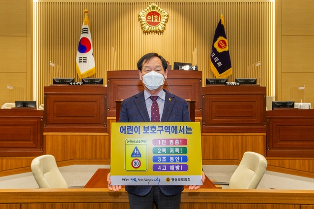 ▲ 고우현 경북도의회 의장이 ‘1단 멈춤! 2쪽 저쪽! 3초 동안! 4고 예방!’ 표어를 들고 어린이 교통안전 릴레이 챌린지 캠페인에 동참했다.ⓒ경북도의회