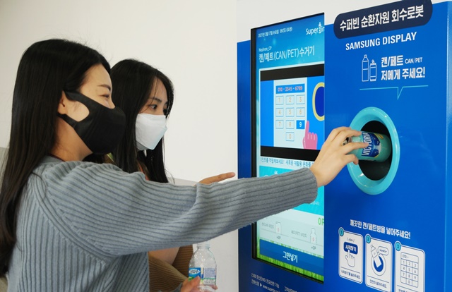 ▲ 삼성디스플레이 직원들이 아산1캠퍼스에 설치된 '스마트 재활용 수거함'을 이용하는 모습. ⓒ삼성디스플레이