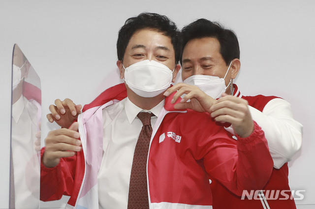 ▲ 오세훈(우) 국민의힘 서울시장 후보가 24일 오전 서울 여의도 국민의힘 당사에서 열린 선거대책위원회 회의에서 금태섭(좌) 전 의원게 당복을 입혀주고 있다. ⓒ뉴시스(사진=국회사진기자단)