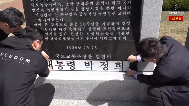 ▲ 유튜브 채널 '가로세로연구소'의 김세의 대표, 강용석 소장, 김용호 전 기자가 '경부고속도로 준공 50주년 기념비' 하단에 '대통령 박정희'라고 적힌 스티커를 부착하고 있다. ⓒ가로세로연구소 방송 화면 캡처