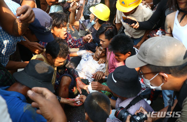 ▲ 군경에게 피격당한 사람을 옮기는 미얀마 반쿠데타 시위대. ⓒ뉴시스 AP. 무단전재 및 재배포 금지.