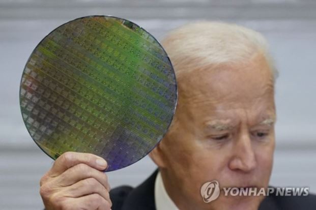 ▲ 조 바이든 미국 대통령이 12일(현지시간) 백악관 루즈벨트룸에서 반도체 업계 대표들과 화상 회의를 진행하는 도중 실리콘 웨이퍼를 꺼내들고 있는 모습. ⓒ연합뉴스