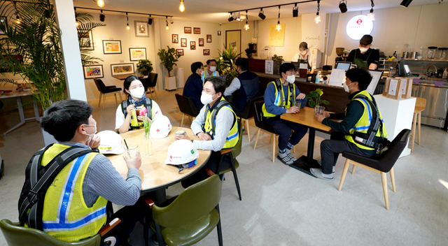 ▲ 롯데건설 현장 내 장애인 바리스타 카페에서 직원들이 주문한 커피를 마시고 있다. ⓒ 롯데건설