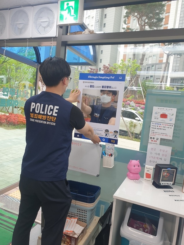 ▲ 충북 청주상당경찰서 한 경찰관이 무인점포에 양심 거울을 설치하고 있다.ⓒ청주상당경찰서