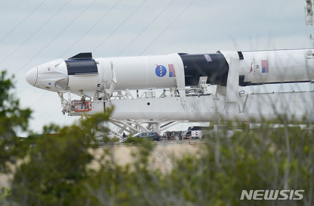 ▲ 지난해 5월 발사 전에 찍힌 스페이스X의 로켓과 우주선. 왼쪽 끝에 원뿔처럼 보이는 것이 우주선 '크루 드래곤'이고, 원통처럼 보이는 게 '팰콘-9' 로켓이다. ⓒ뉴시스 AP. 무단전재 및 재배포 금지.